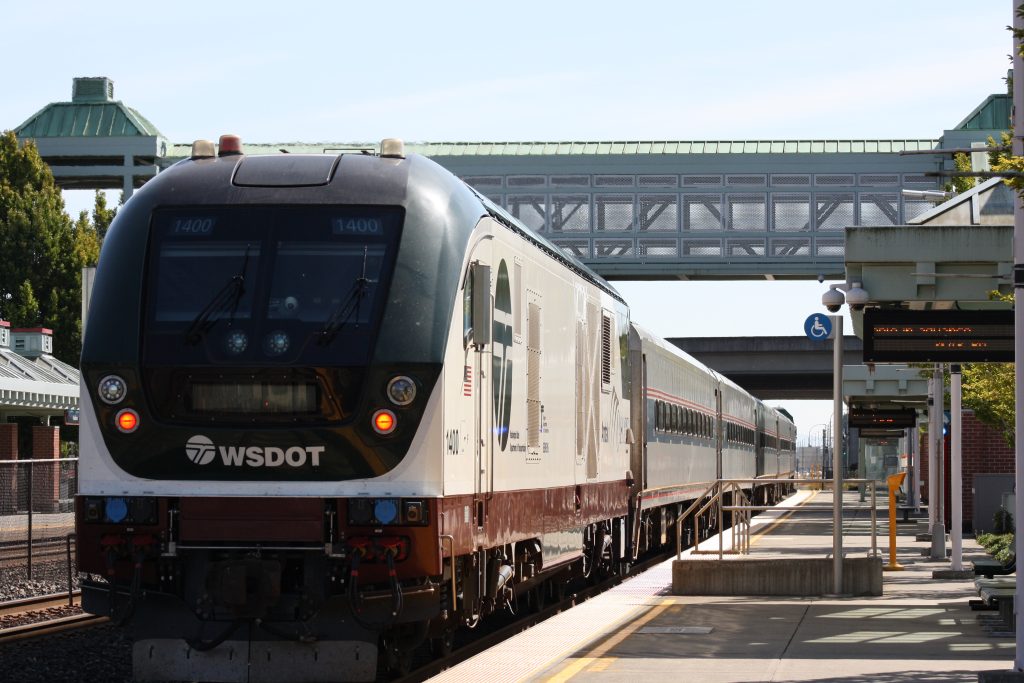 An Amtrak Cascades train painted in several shades of brown stopped at a platform. 
