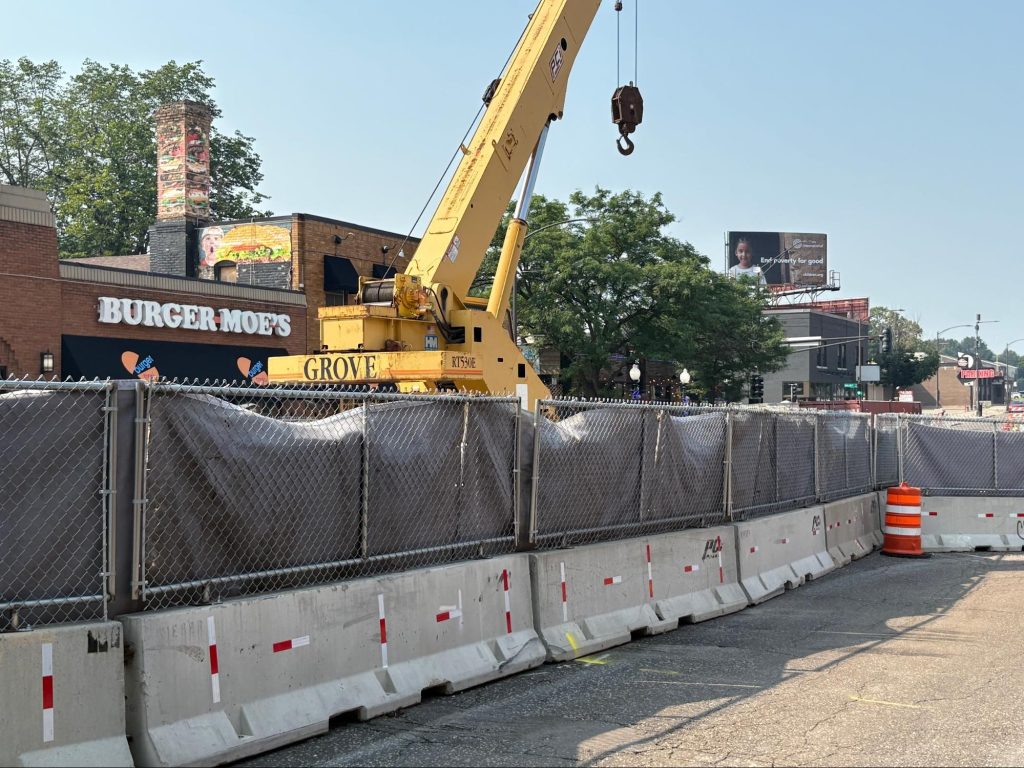 A crane continuing repair on West Seventh work in front of Burger Moe's.