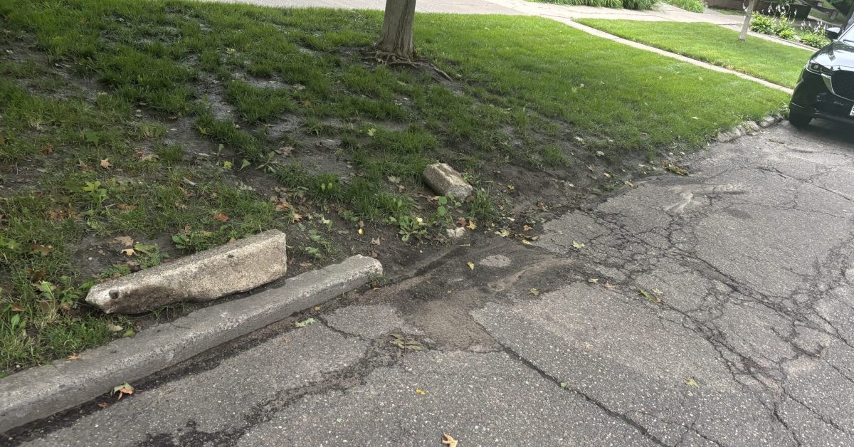 Crumbling pavement on Summit Avenue next to the green median.