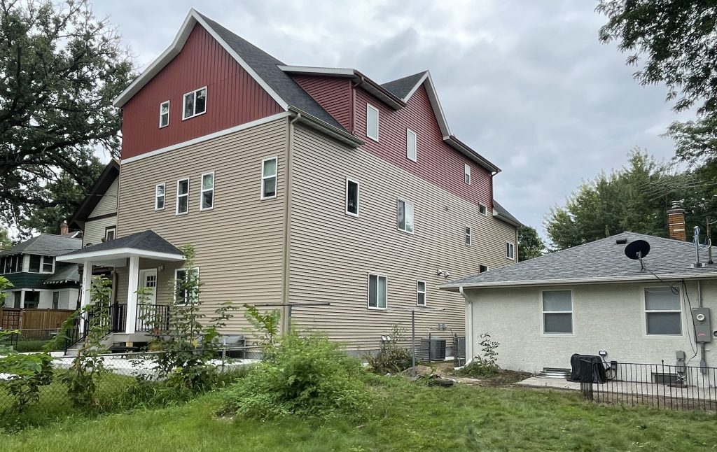 A three-story building towers over a single-story home in the Mac-Groveland neighborhood of St. Paul.