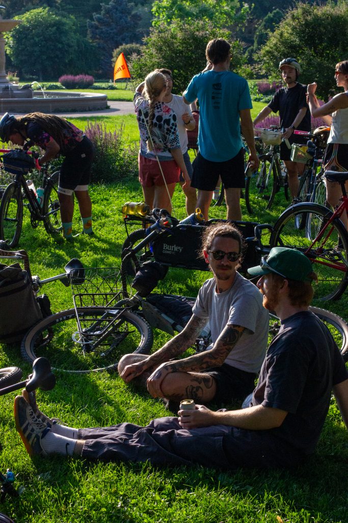 This is a photo featuring a large gathering of cyclists before the ride, socializing, adjusting their gear. 