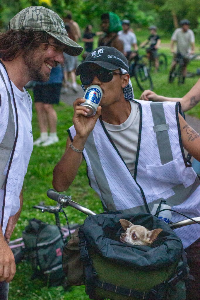 Co-founder of Genosack Justin You sipping a Fat Tire beer with his partner's puppy resting cozy in the front bag of his bicycle