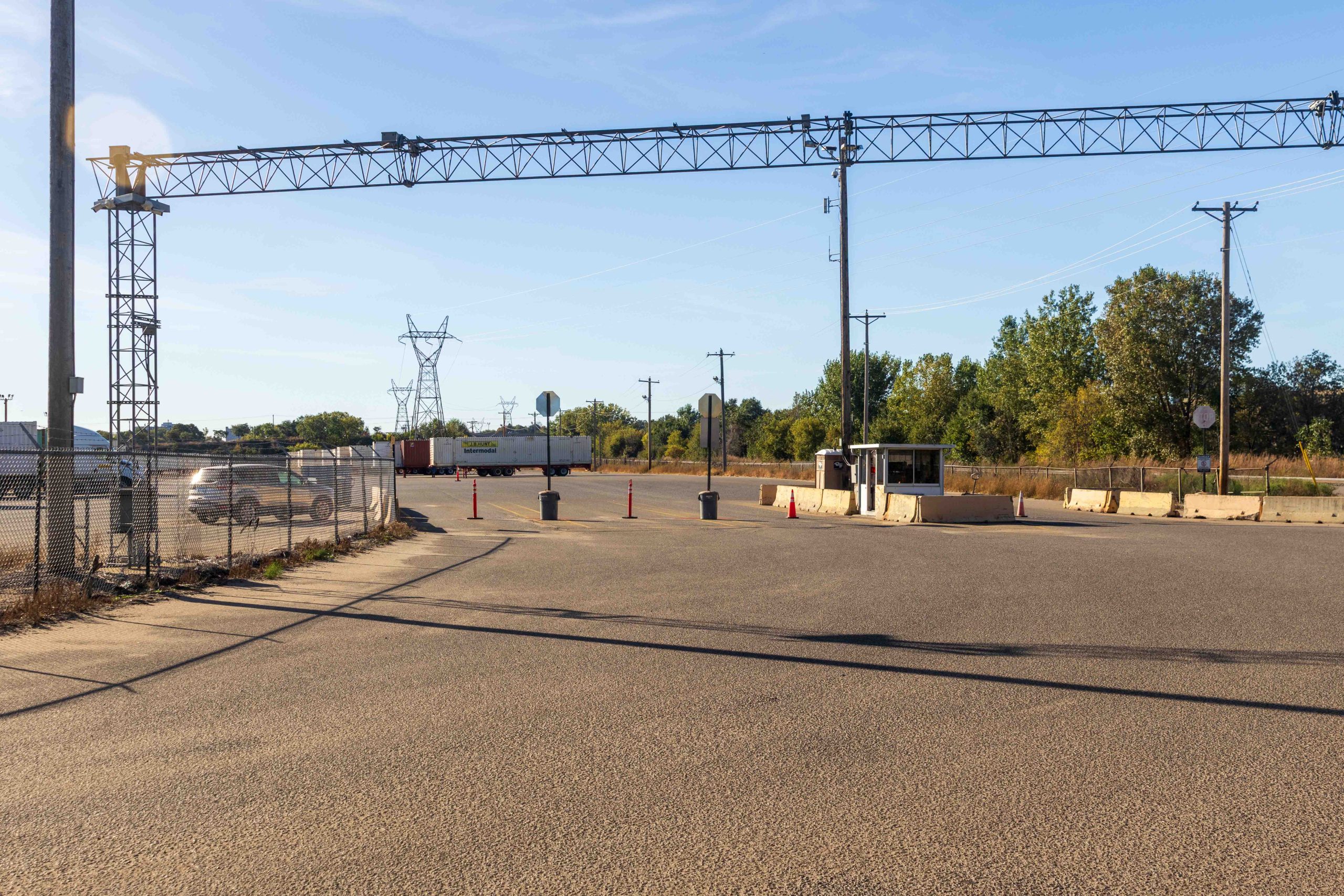 A guard inside the entry booth across a wide stretch of road.
