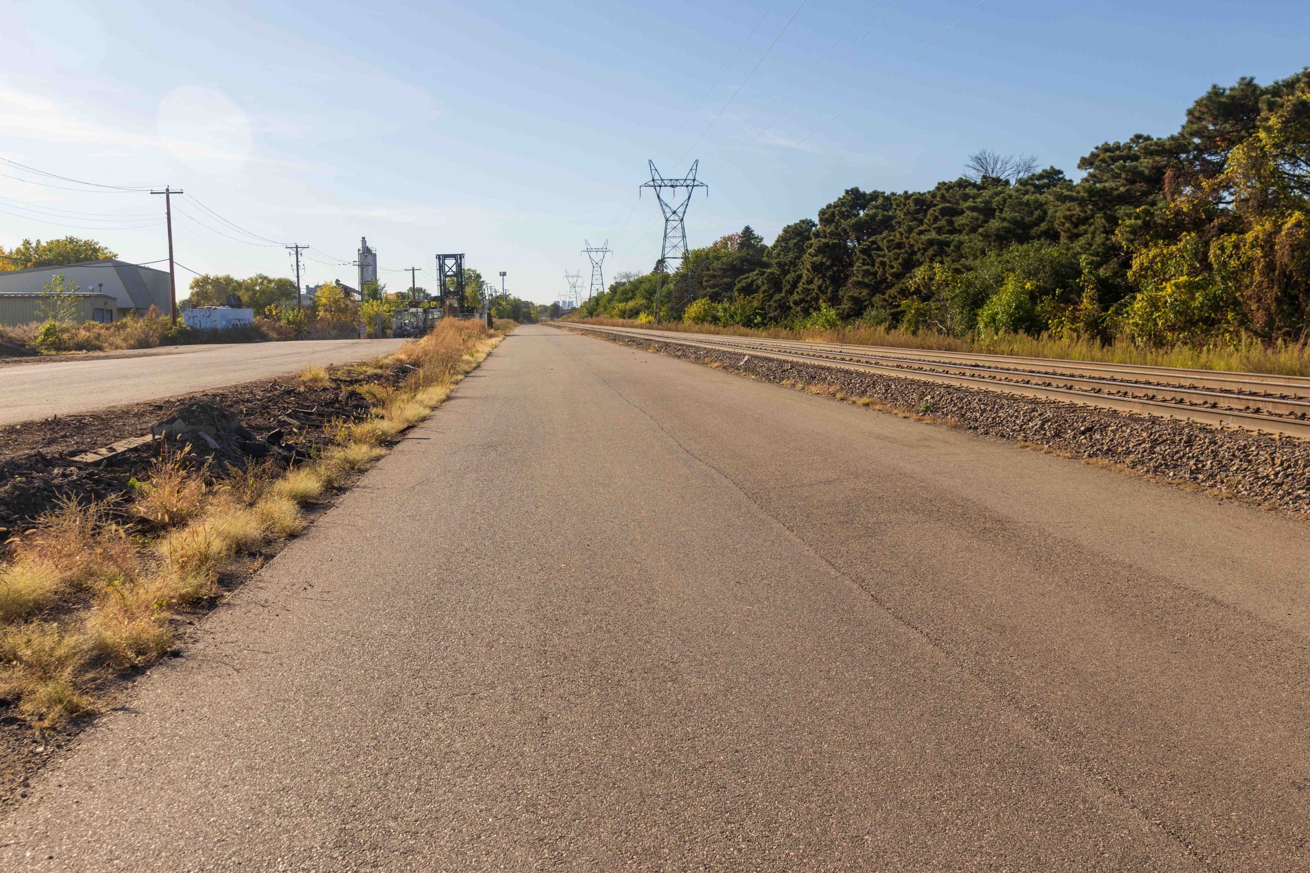 The road next to the railway appears to go to on to the horizon in this view looking west.