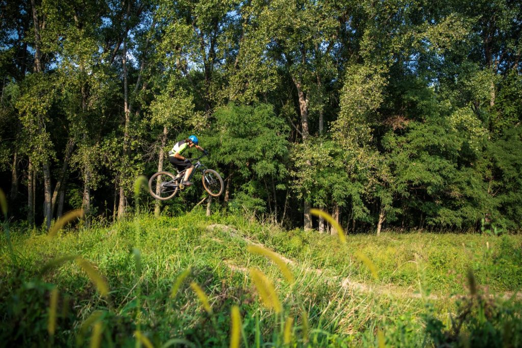 A young cyclist jumps his bike in the air on an obstacle course.