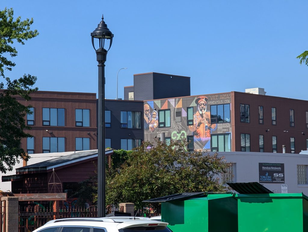 Building visible behind some foreground clutter with a large mural