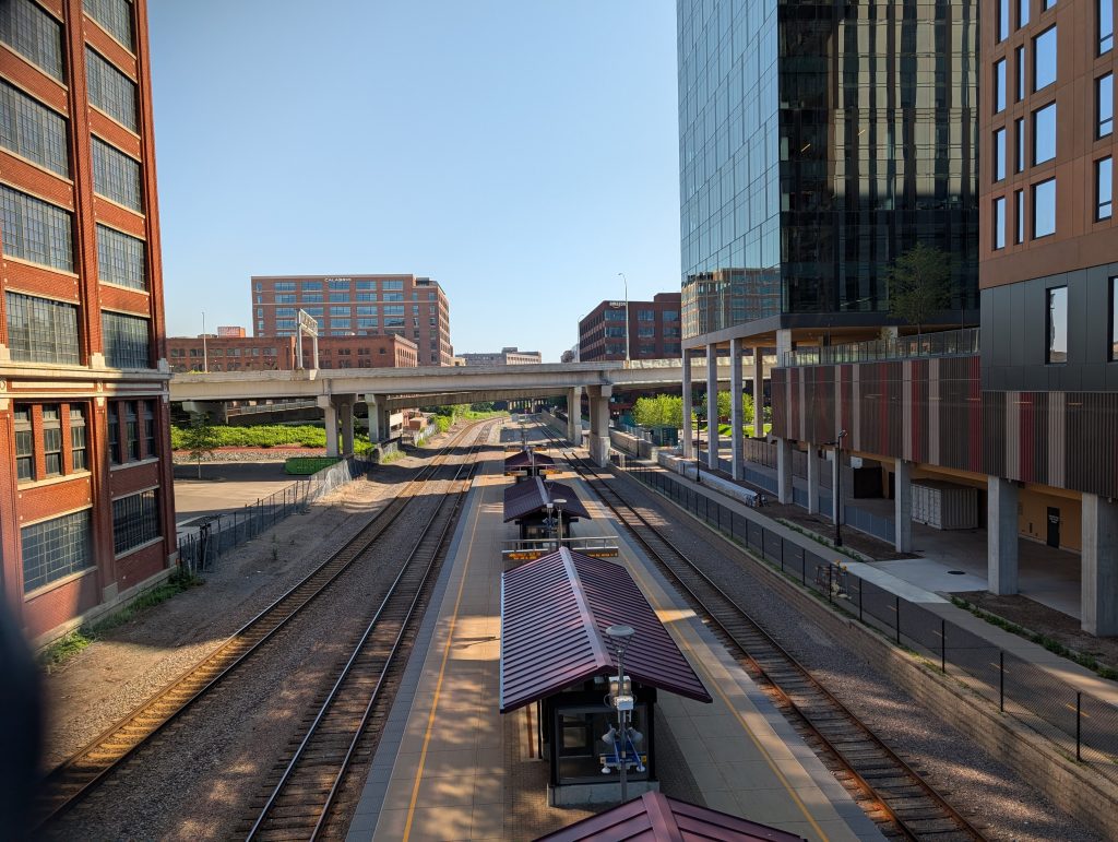 Railroad tracks between buildings with station platform between the tracks