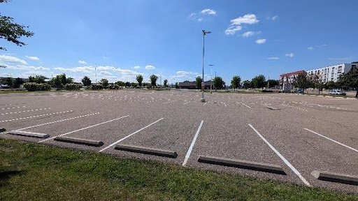 Empty expanse of a massive parking lot near the Midway Target, lined with trees and apartment buildings in the background.
