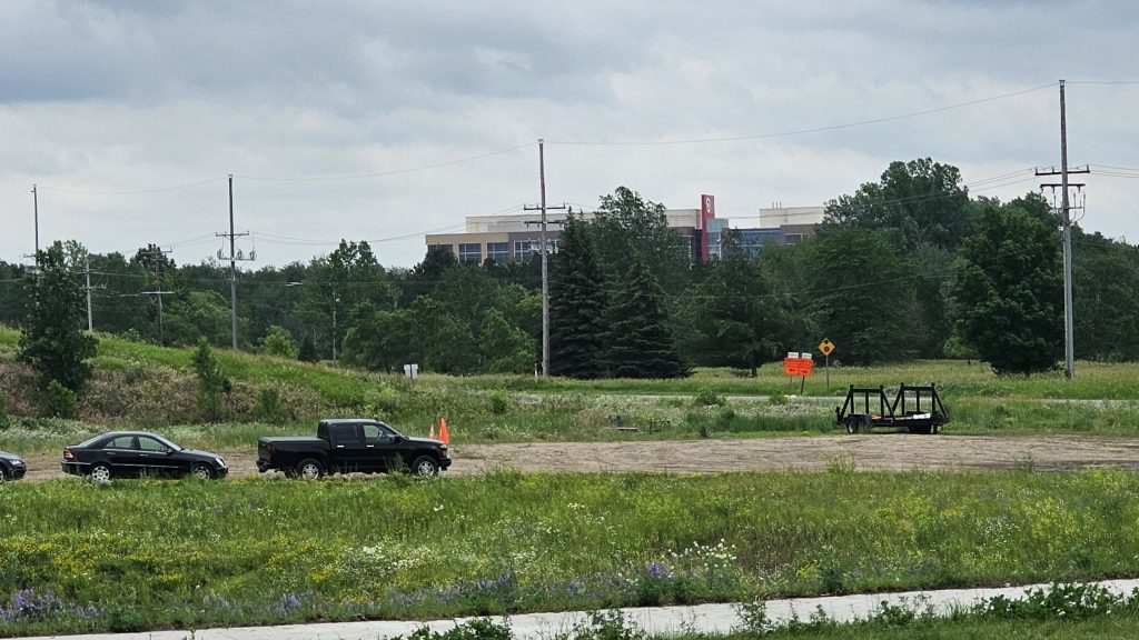 Looking southwest towards the Target Northern Campus offices in Brooklyn Park from Xylon Avenue and 101st Avenue. The space is green with one main road and some buildings behind trees.