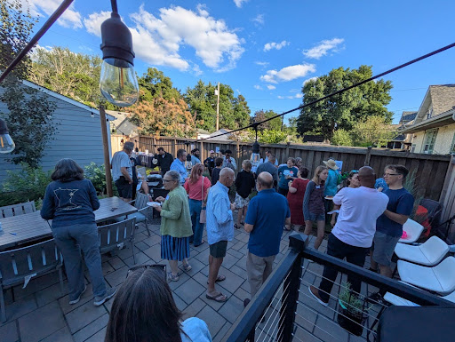 People standing in a back yard for mayoral candidate forum.