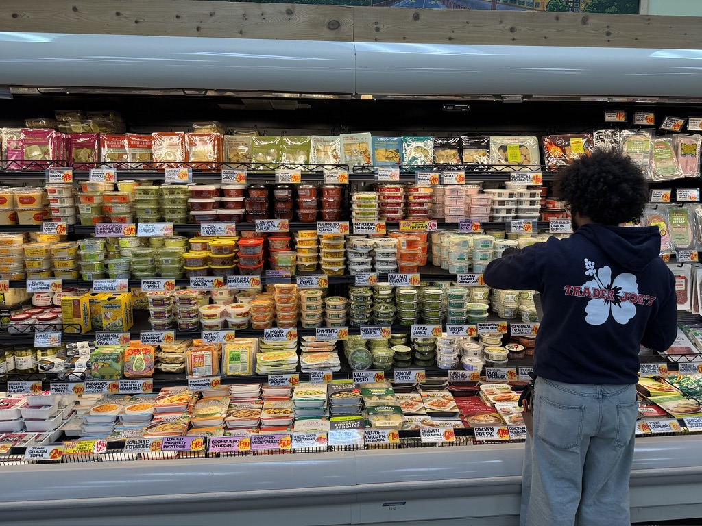 A grocery store worker restocks the shelves in the dips and spreads section of Trader Joe's in Downtown Minneapolis.