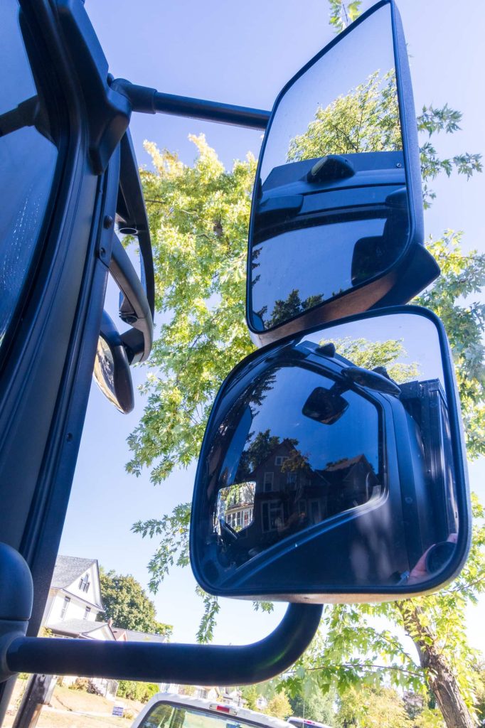 The two passenger side mirrors reflect parts of the cab of the Mercedes.