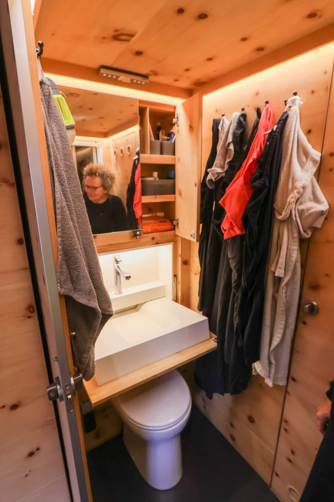 Ingrid reflected in the bathroom mirror. Sink, and below it, toilet, are visisble