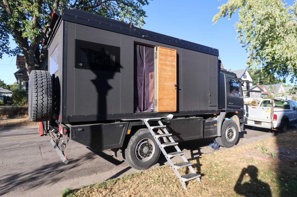 RV parked on street with door open and steps extended