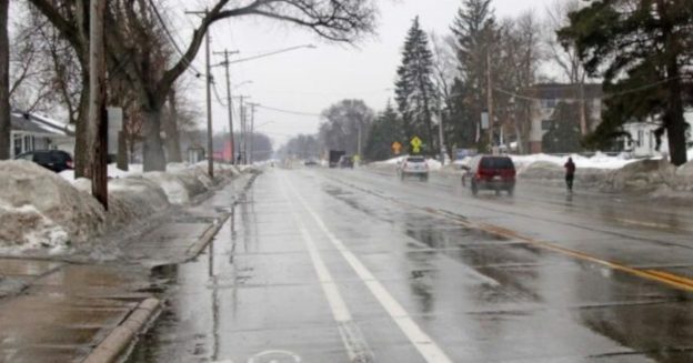 A photograph showing Nicollet Avenue on a rainy day with a bike lane in the foreground.