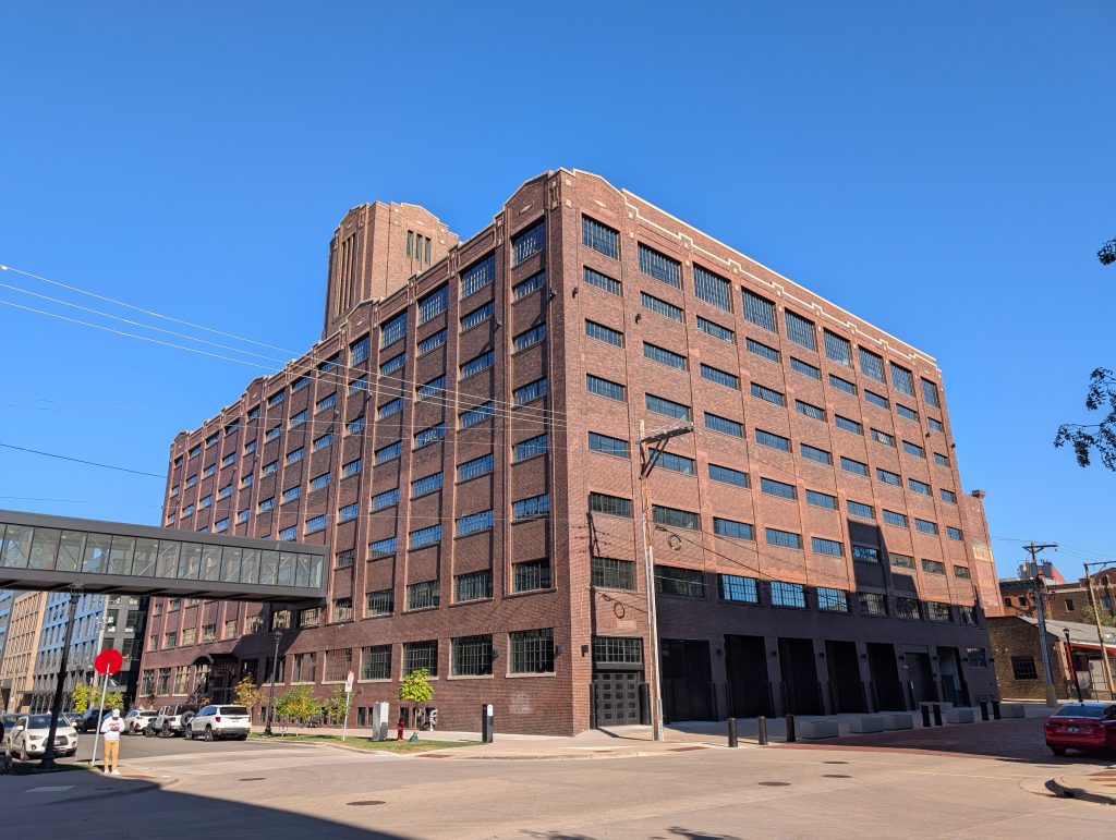red-brick commercial-style building with decorative parapet and tower