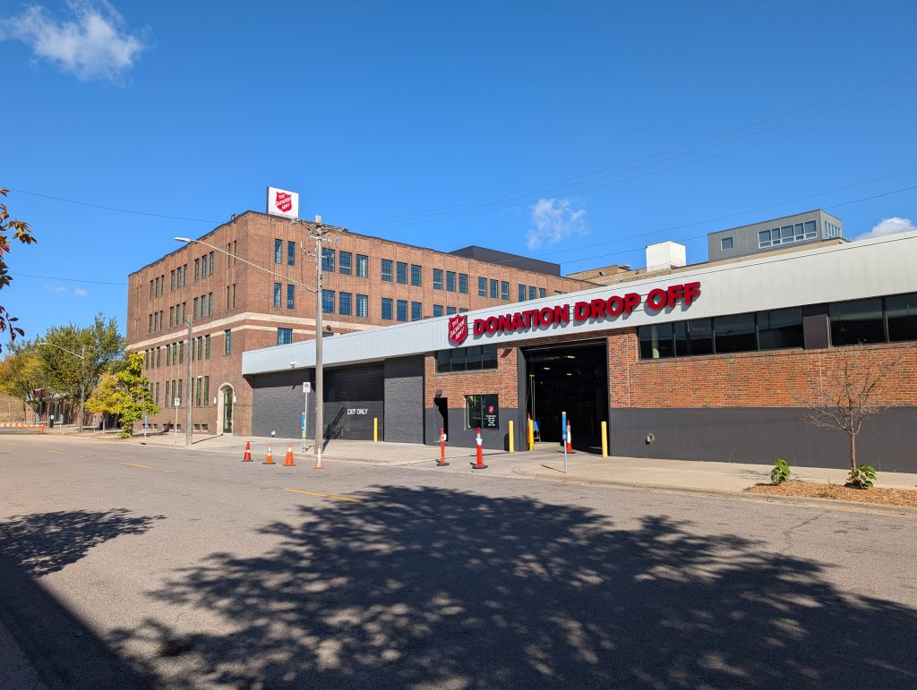 single-story donation drop-off area with four-story building beyond it