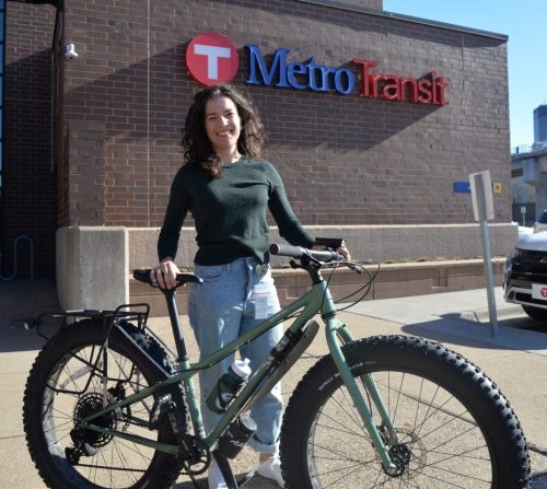 Valenti is pictured with a fat bike in front of a Metro Transit building.