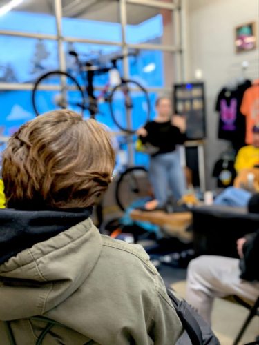 View from the audience as a presenter holds up a shoe.
