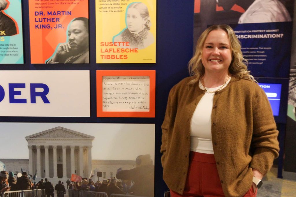 Rebeccah Parks, public information officer for the Eighth U.S. District Court, standing next to a display inside the Justice & Democracy Center of Minnesota.