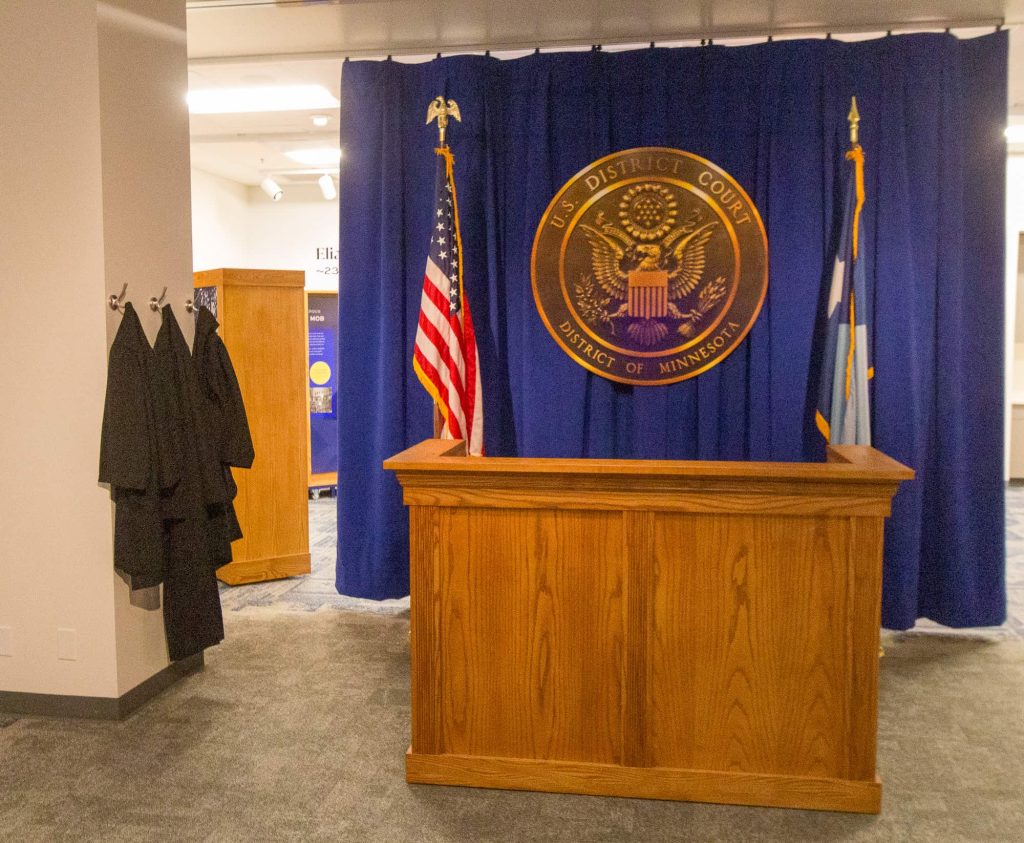 Student-sized judges robes hang next to the Judge’s bench.