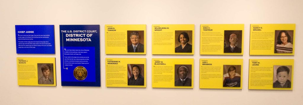 Photos and biographies of the justices mounted on a wall in the Justice & Democracy Center.