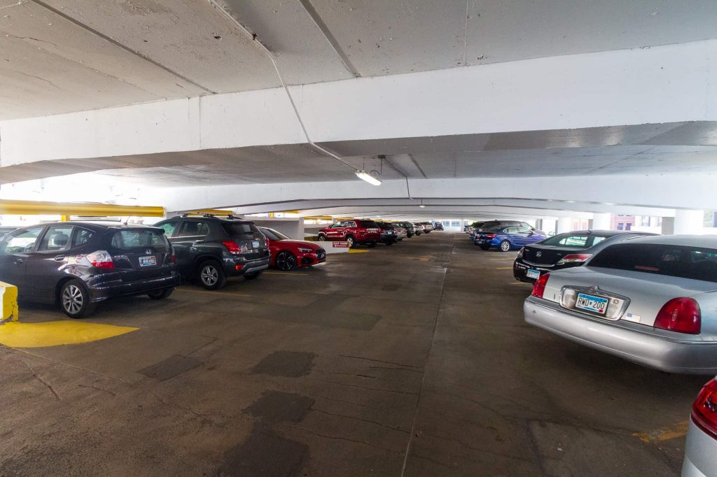 A parking ramp with more than three-quarters of the parking spaces filled with cars.