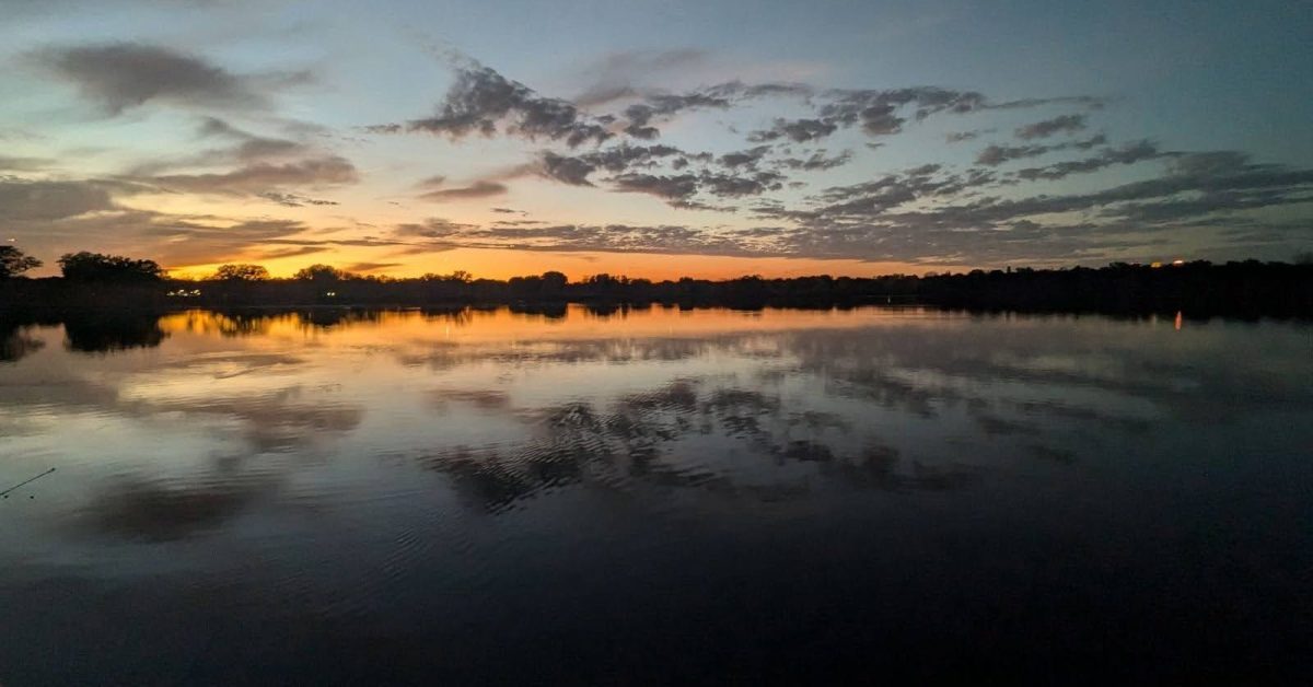 Sunset with clouds over a lake.