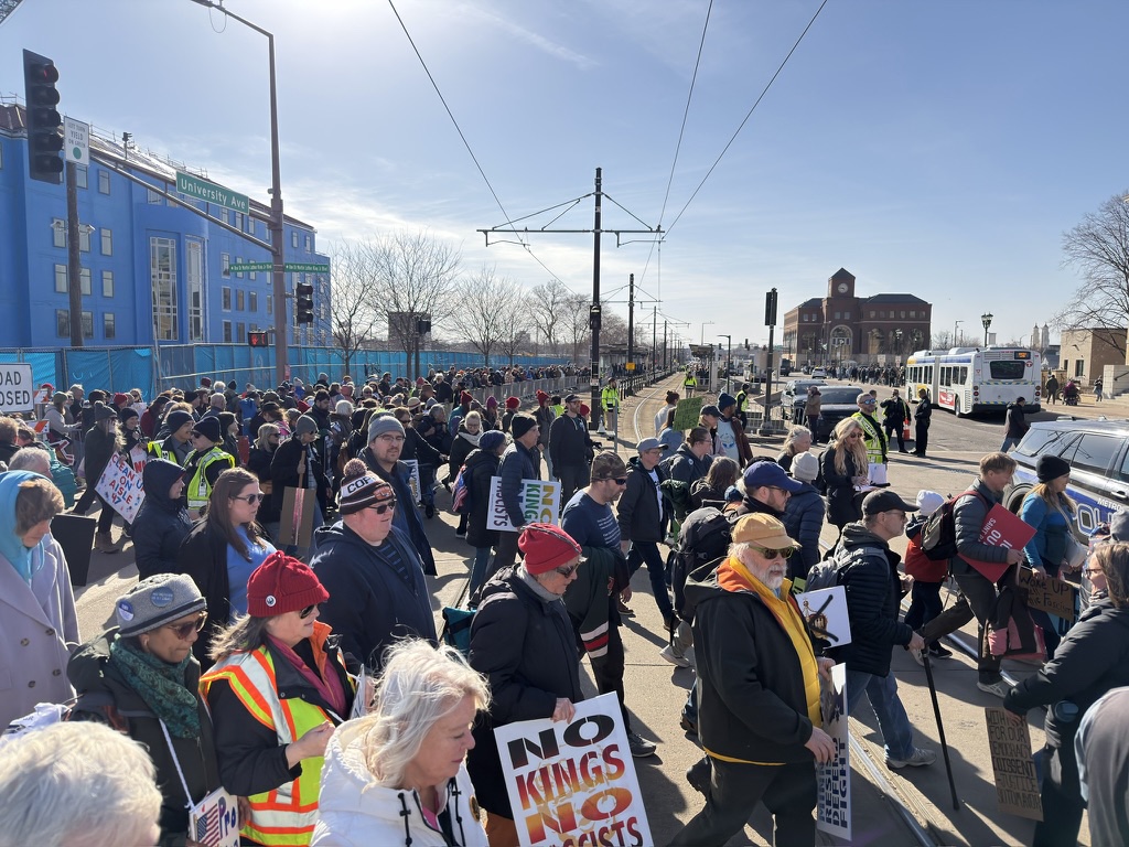 Demonstrators at No Kings 3 cross University Avenue and go to queues for buses and light rail on Saturday, March 28, 2028. Photo: Conrad Lange Zbikowski
