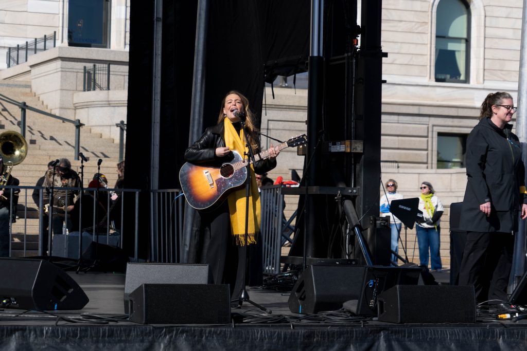 Musician Maggie Rogers performs at No Kings 3 in St. Paul Minnesota on Saturday, March 28, 2026 with an acoustic guitar. Photo: Conrad Lange Zbikowski