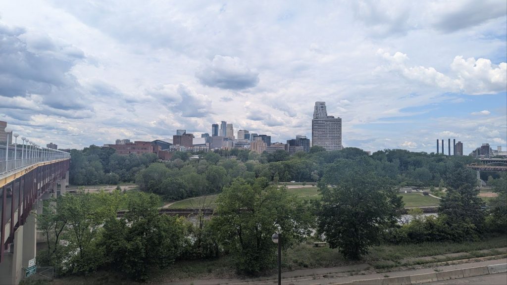 Minneapolis skyline, with parkland and the Mississippi River in the foreground.