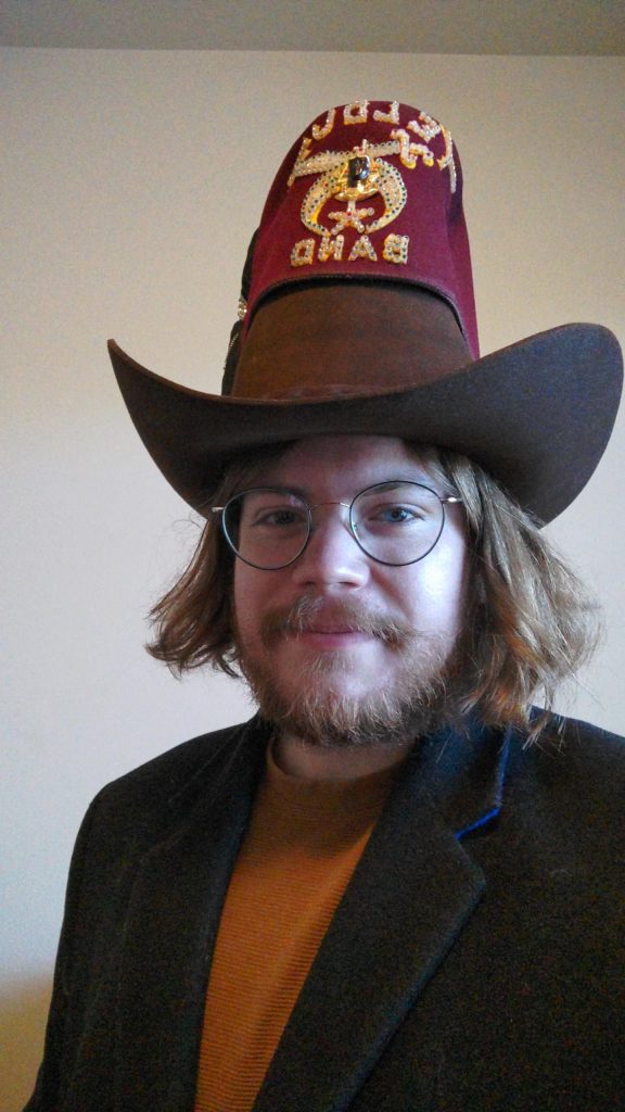Parker Seaman wearing a nice jacket and large cowboy hat with another hat on top of it