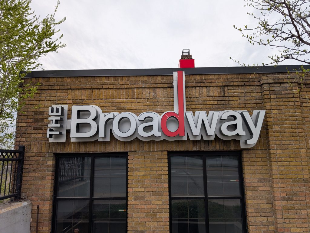 photo of brick-faced building with sign "The Broadway"