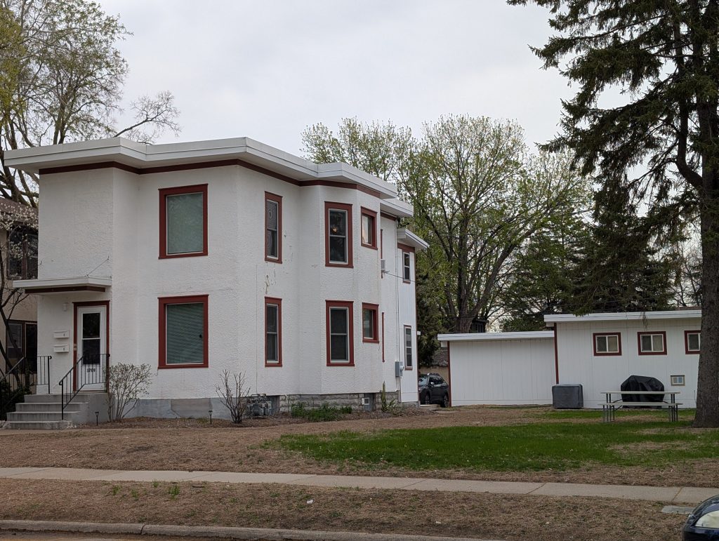 white two-story building with protruding flat roof
