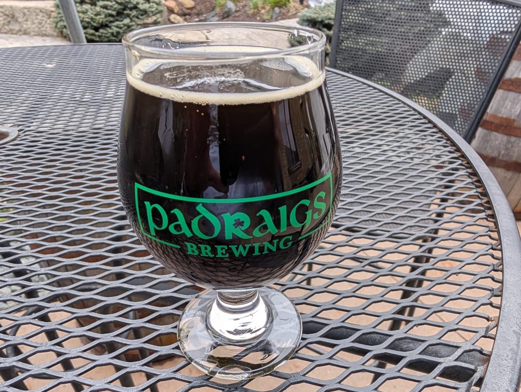 glass of dark beer on picnic table