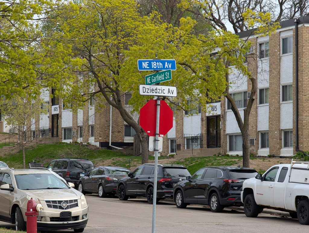 Street sign at intersection of NE Garfield St and NE 18th Av, which has the additional designation Dziedzic Av