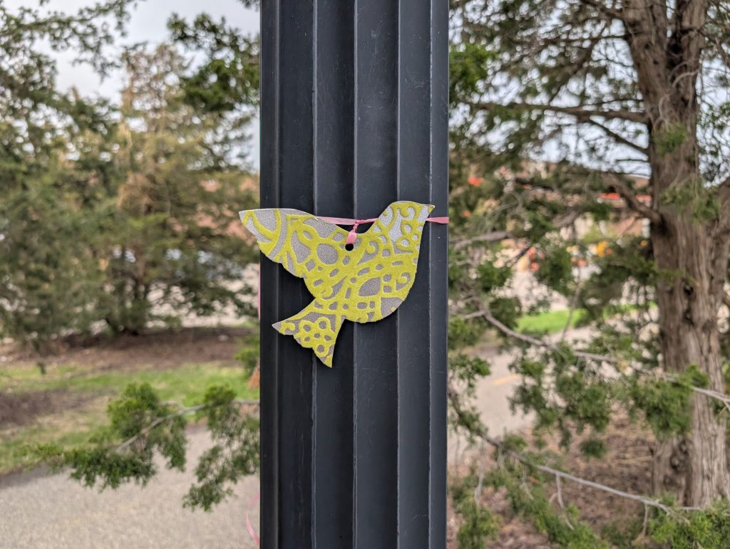 Dove cutout tied with ribbon around fluted post