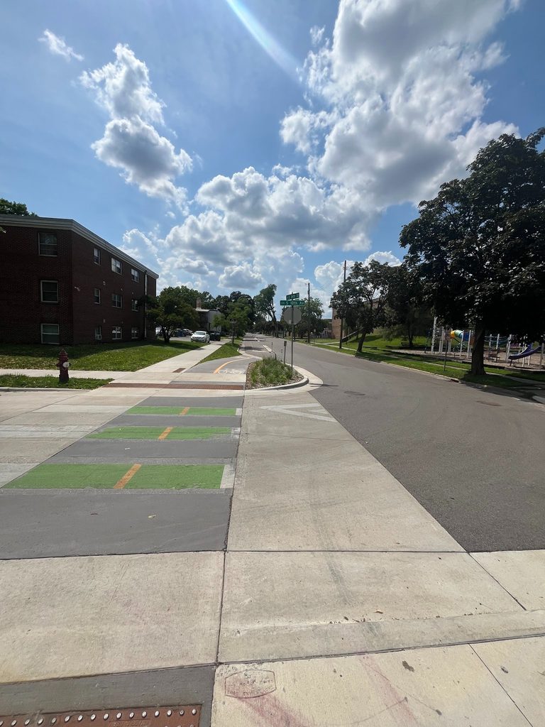 This photo from 34th Street East at 10th Avenue South shows a tabled crossing in the foreground and, beyond that, a two-way, on-street bikeway.