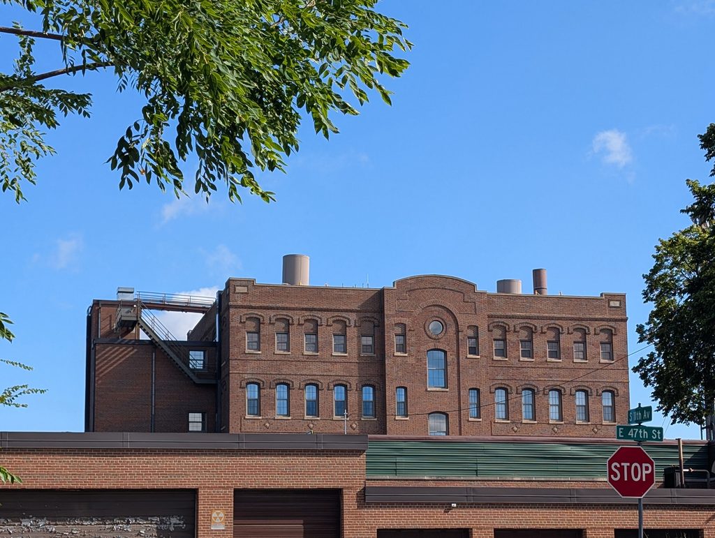 large brick building viewed over the top of garages