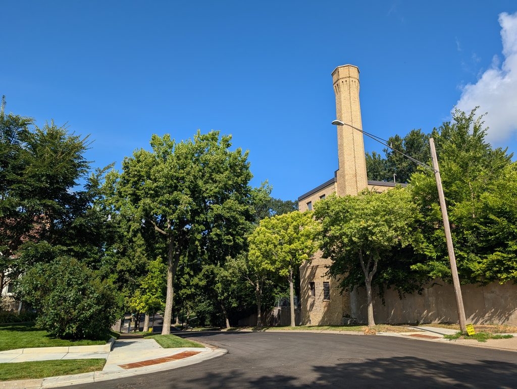 yellow brick chimney visible behind trees