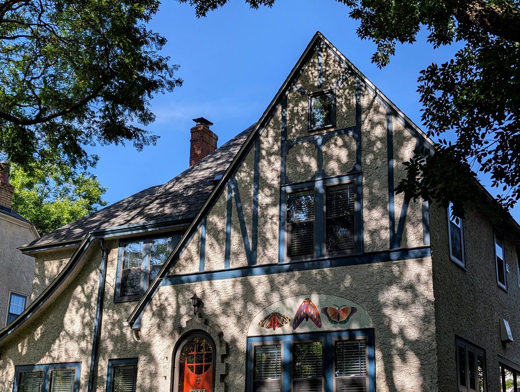tudor revival facade with mosaic of lepidoptera