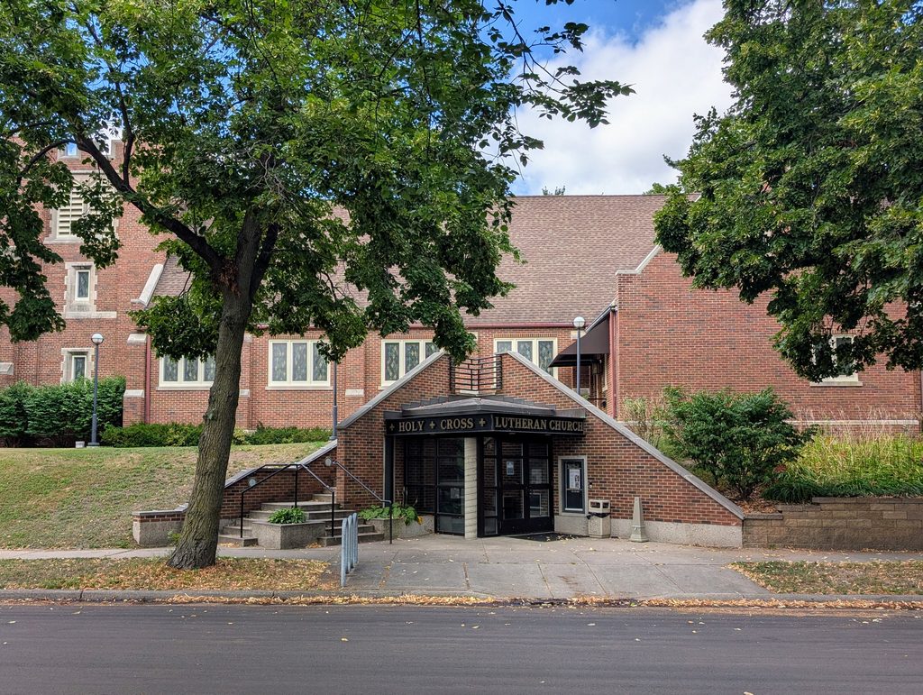 sidewalk-level entrance to church that is visible from the side at a higher elevation