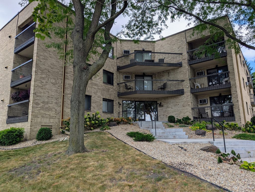 three-story multi-unit residence featuring with entrance in diagonal junction between wings