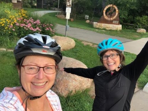 Jo Anne and her "biking buddy" in their bike helmets, smiling big.