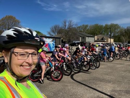 Jo Anne, with a row of kids on bikes in the background.