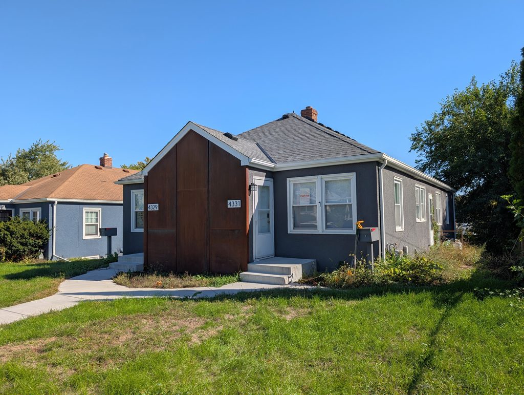 grey stucco duplex with weatherin steel on front