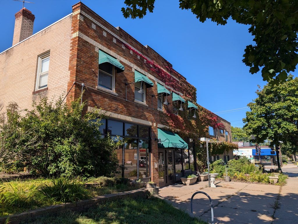 two-story brick building with turquoise awnings