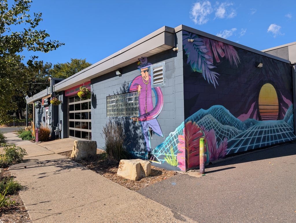 cement block building with garage door and mural